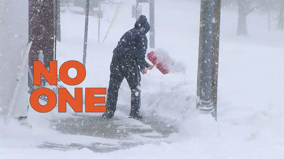 Man shoveling snow in blizzard